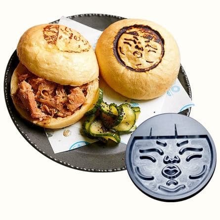 Buns branded with a face logo beside the machined stamp plate that made them