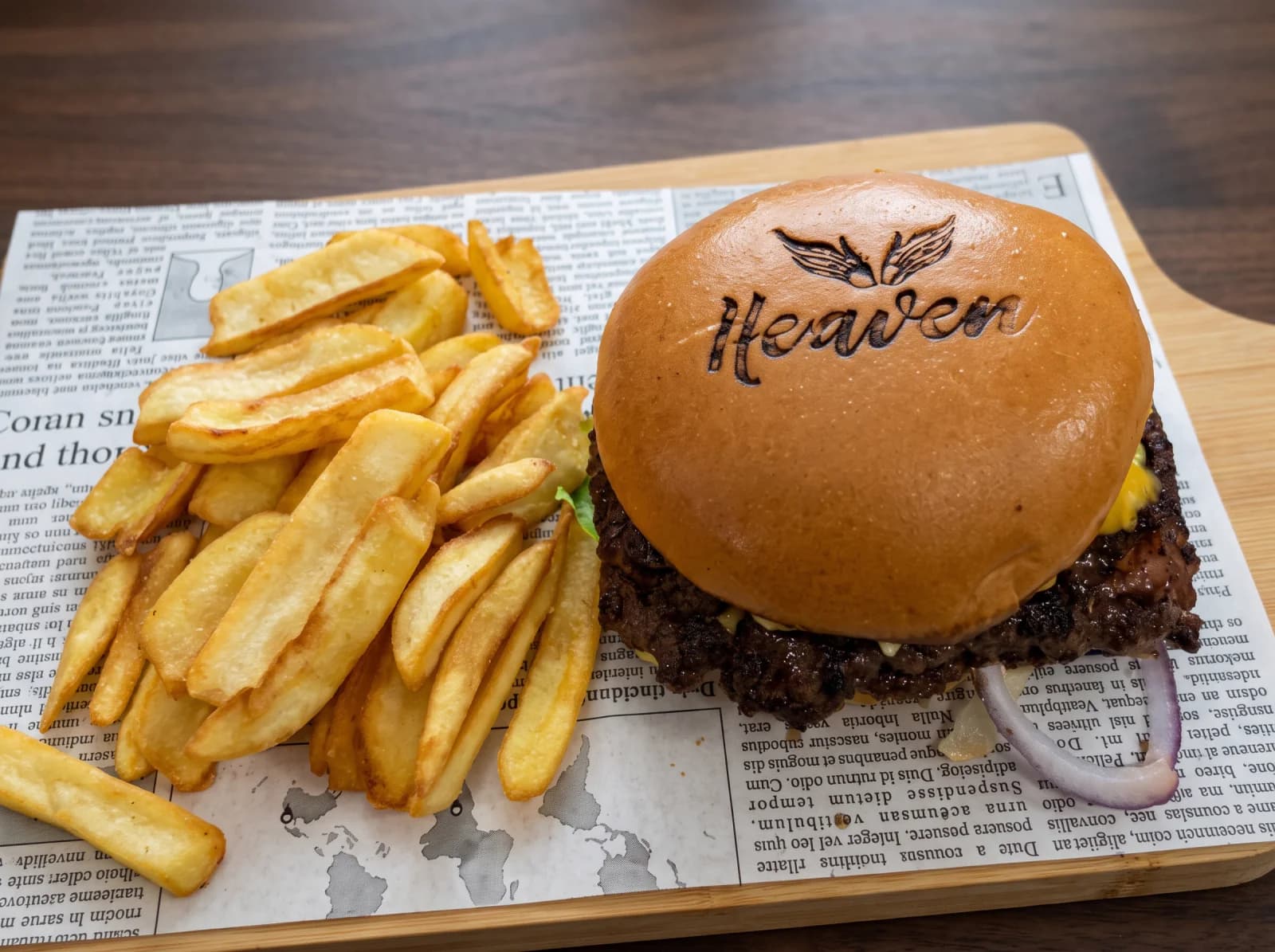 A burger bun branded with the Heaven logo, served with fries